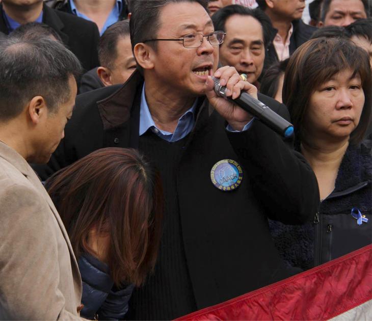 Film subject John Chan speaks at a protest in support of Peter Liang at Cadman Plaza while Peter Liang's mother bends over in distress