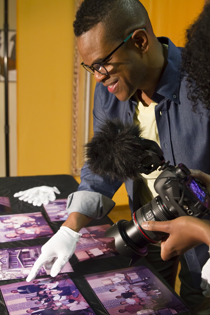 Producer Thomas Allen Harris wears a white glove as he reviews photos in his archive. Credit: UNC-TV
